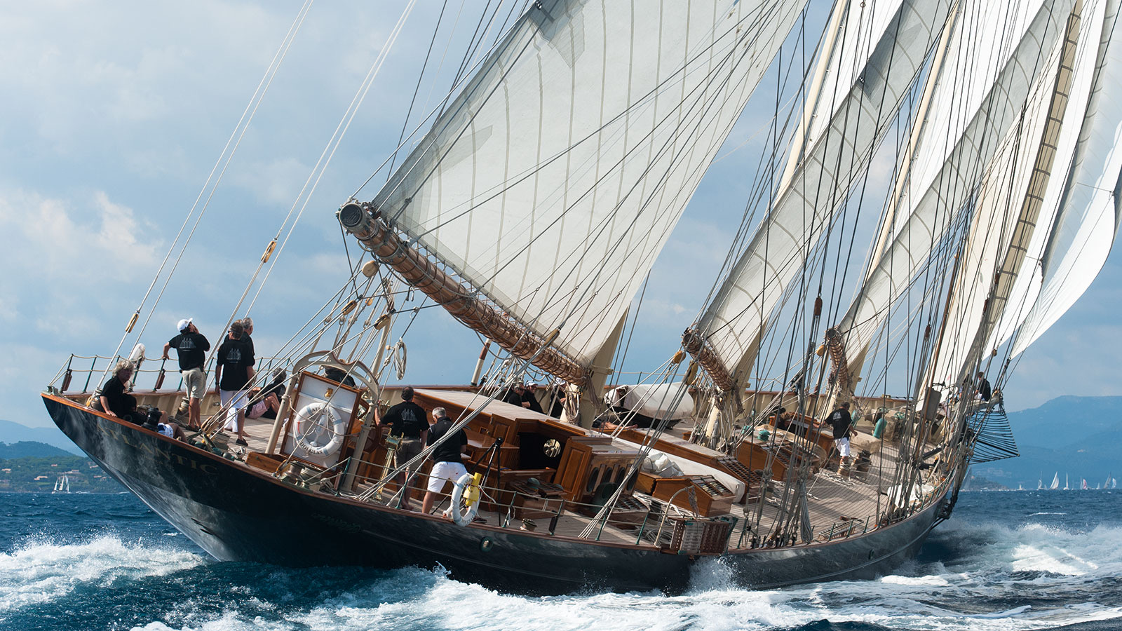 S/Y ATLANTIC heeling under full sail with crew on deck — the largest classic racing schooner ever recreated.